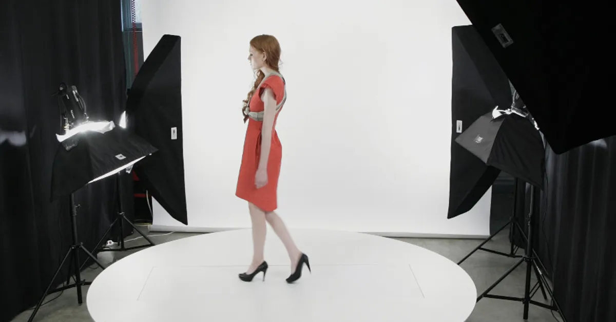 Modell i röd klänning under fotografering i studio.