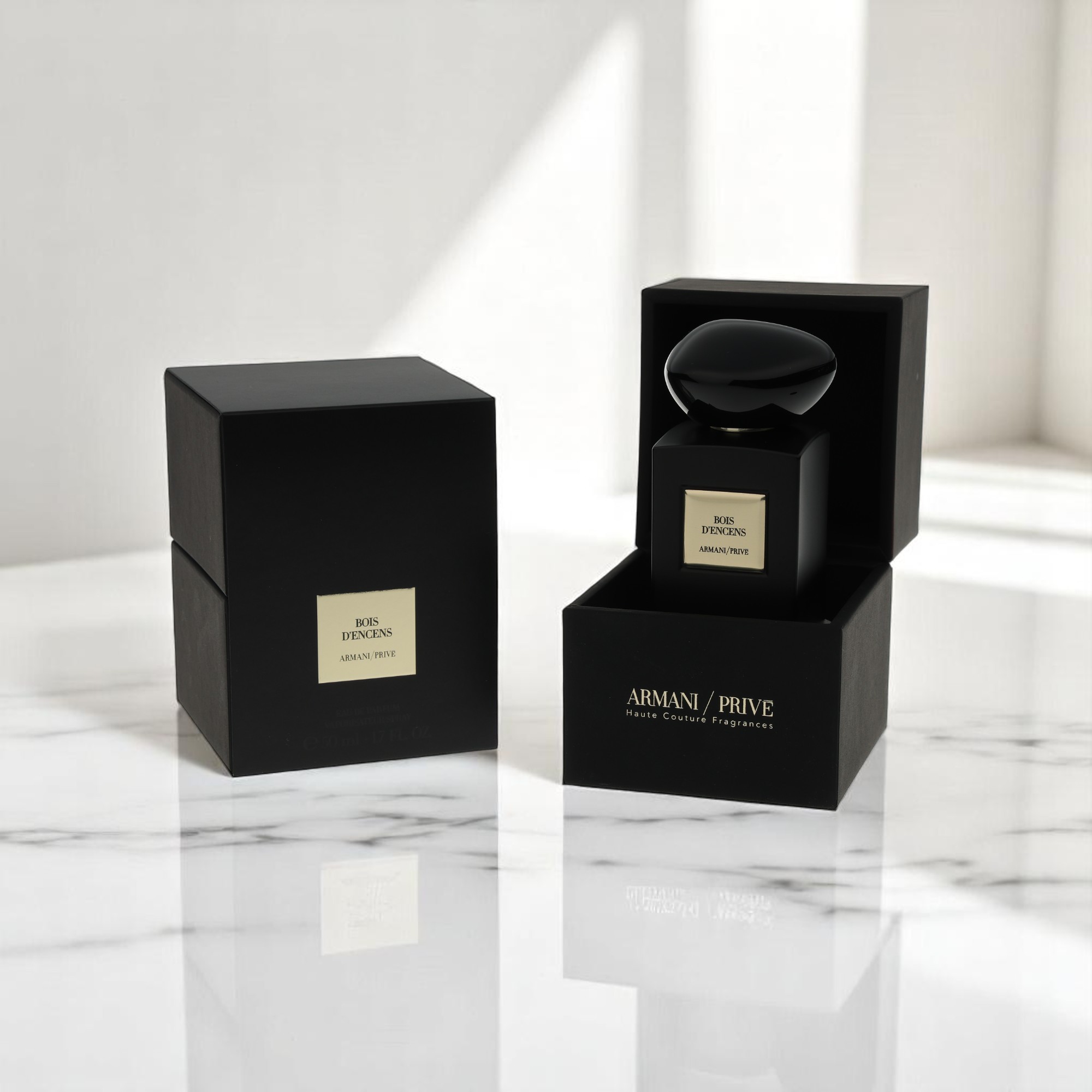 Et packshot viser sort og guld Armani / Prive-parfume på et marmorbord i et godt oplyst rum.